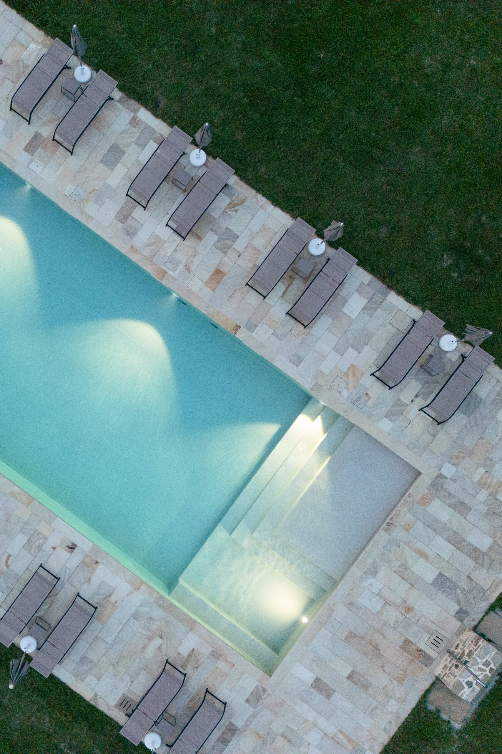piscina illuminata dall'alto con lettini agriturismo Bramalpane